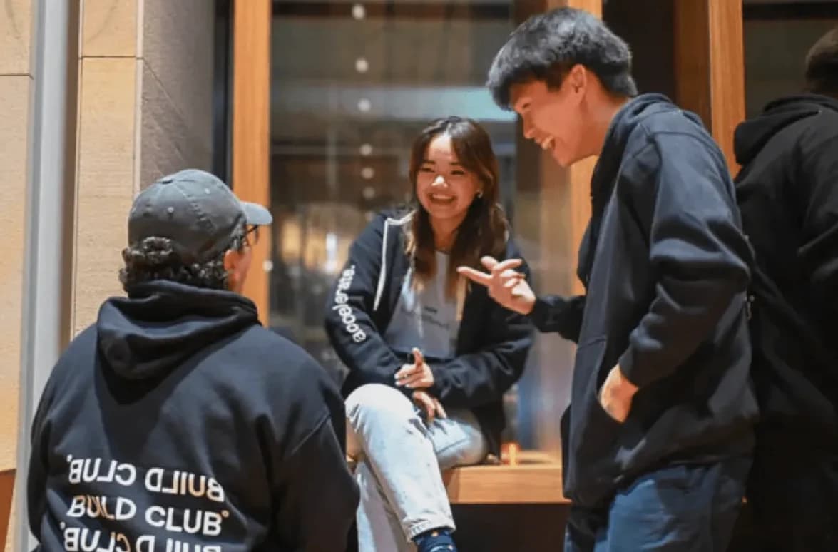 Two Build Club members talk after a meetup. One wears a Build Club hoodie.