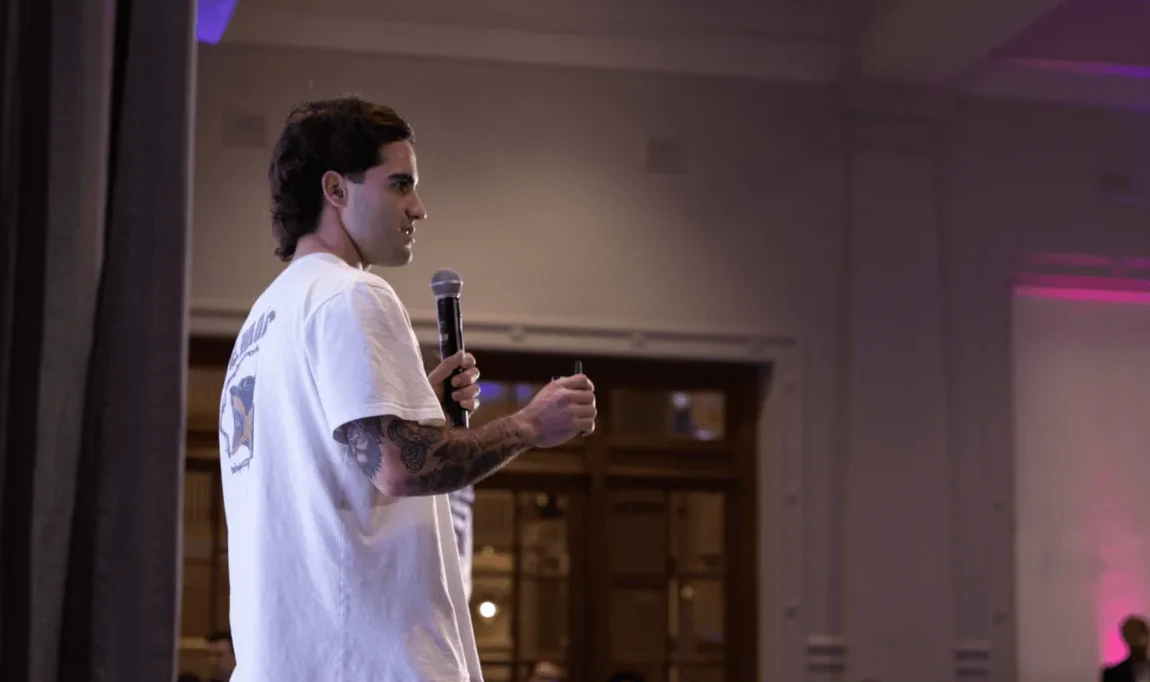 A member speaks to the room with a microphone.
